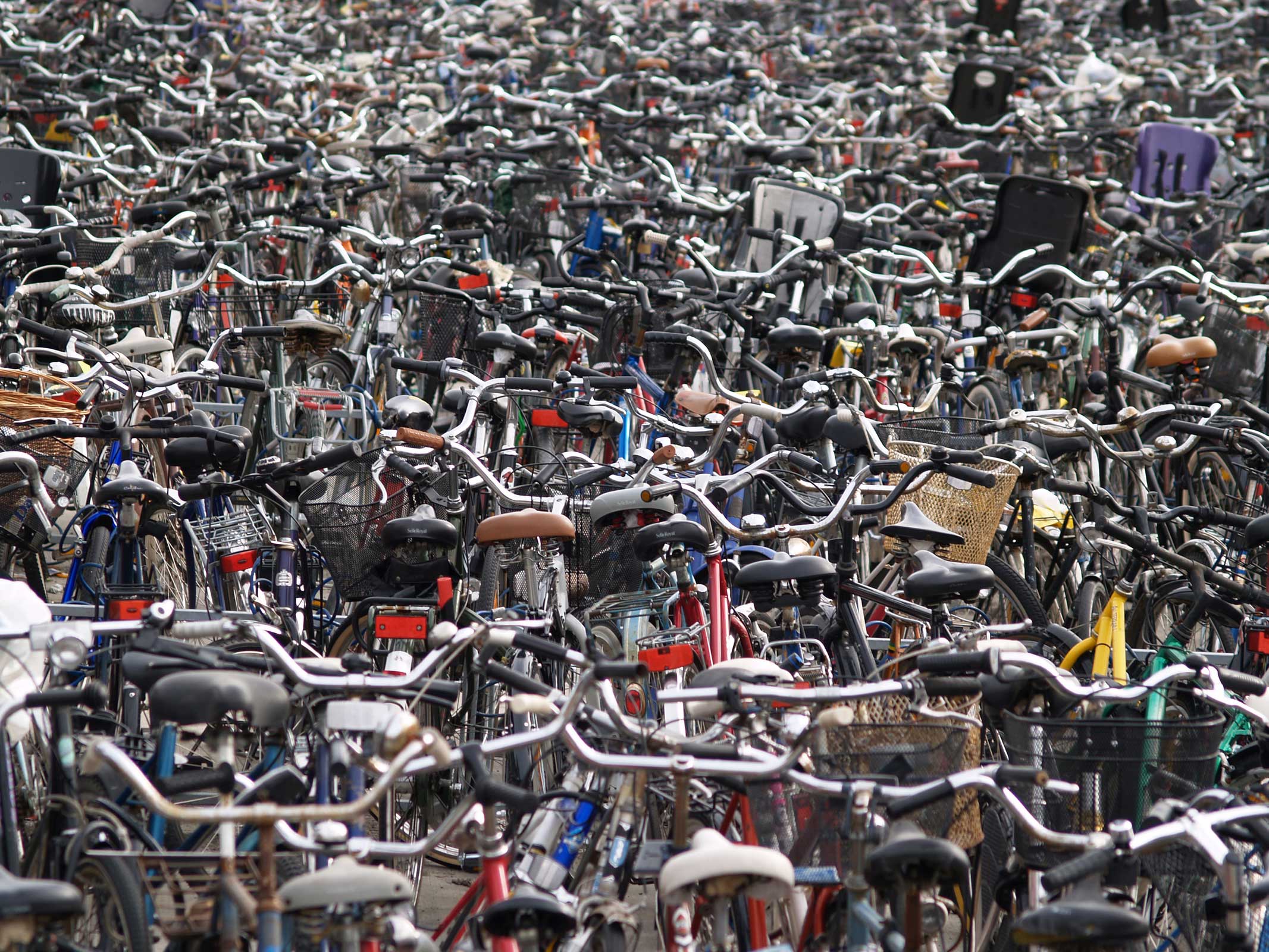 Black-and-white photo of a police officer standing in front of a bike rack.